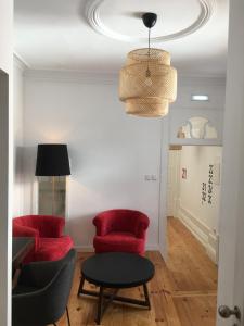 波多的住宿－Pimms Home Ribeira，客厅配有2把红色椅子和桌子