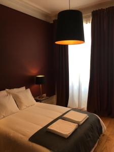 a bedroom with a bed and a lamp at Pimms Home Ribeira in Porto