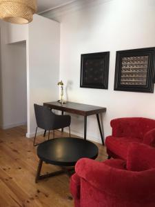 uma sala de estar com um sofá vermelho e uma mesa em Pimms Home Ribeira em Porto