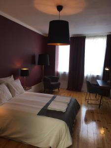 a bedroom with a bed and a chair and a desk at Pimms Home Ribeira in Porto