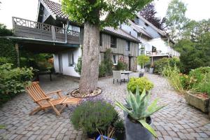 un patio con un árbol, sillas y una mesa en Kleines Haus mitten in der Natur mit eigener Terrasse und Sonnenbalkon, en Halver