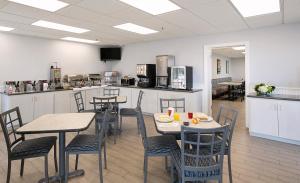 a room with tables and chairs and a kitchen at Pismo Lighthouse Suites in Pismo Beach