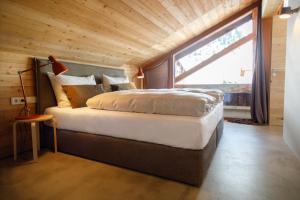 a bedroom with a large bed with a large window at Lenai & Linai Apartments in Lech am Arlberg