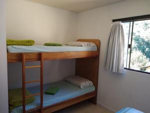 2 Etagenbetten in einem Zimmer mit Fenster in der Unterkunft Hostel Dina & Suítes in Pomerode