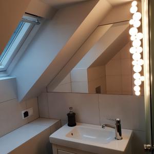 W łazience znajduje się umywalka i lustro. w obiekcie Willa Azalia w Polanicy Zdroju