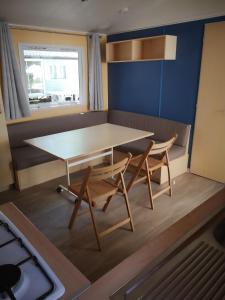 a small kitchen with a table and two chairs at Mobil home climatisé en Vendée in La Boissière-de-Montaigu