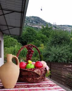 a basket of fruit on a table with a vase at Syunyats guest house in Halidzor