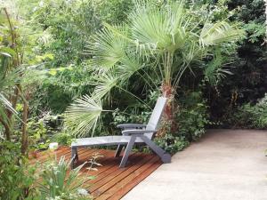 a chair sitting on a wooden deck in front of plants at Les Vignes du Château Duras Wifi et Belle vue in Duras