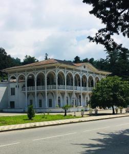 a large white building on the side of a road at Yellow room with sea view in Makhinjauri