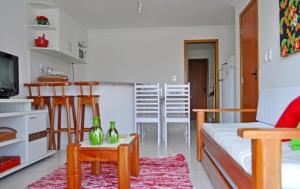 a living room with a couch and a table and a kitchen at Residencial Mont Sião - Tonziro in Porto Seguro