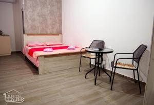 a bedroom with a bed and a table and chairs at Hostel Center in Ulcinj