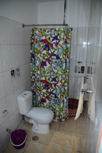 un bagno con un water e una tenda da doccia di Meeting Point- Tarrafal Center, also in Praia & Fogo-NO CASH ACCEPTED a Tarrafal