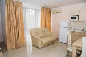 a living room with a chair and a refrigerator at Apart Lev in Ravda