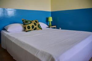 un grande letto bianco con parete blu di Meeting Point- Tarrafal Center, also in Praia & Fogo-NO CASH ACCEPTED a Tarrafal