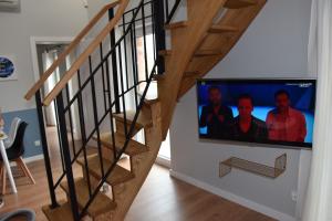 a staircase with a flat screen tv in a living room at VerrAri Apartaments in Łeba