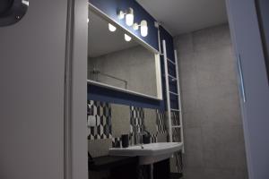 a bathroom with a sink and a mirror at VerrAri Apartaments in Łeba