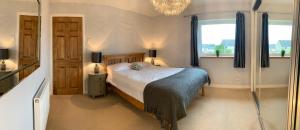 a bedroom with a bed and two windows at Dwarwick House in Thurso