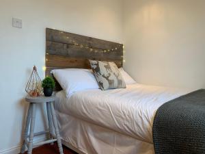 a bedroom with a bed with a wooden headboard at Dwarwick House in Thurso