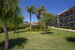 um parque em frente a um edifício com palmeiras em Viviendas Uso Turistico Fontiña - Playa Montalvo Sanxenxo em Sanxenxo