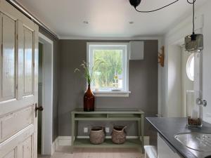 a kitchen with a vase on a counter and a window at Station Bed and Kitchen Guesthouse in Varberg