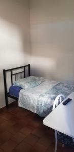 a bedroom with two beds and a desk and a table at Quarto particular em Vitória in Vitória