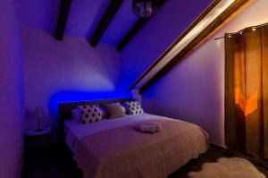 Dormitorio con cama con iluminación púrpura en King Suite, en Mlini