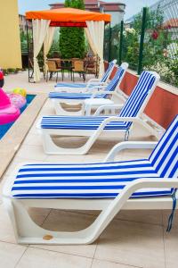 a group of lounge chairs sitting on a patio at Apart Lev in Ravda
