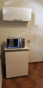 a microwave sitting on top of a white refrigerator at Quarto particular em Vitória in Vitória