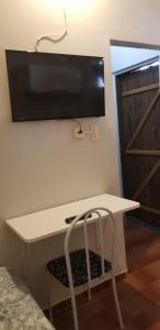 un escritorio blanco con TV en la pared en Quarto particular em Vitória en Vitória