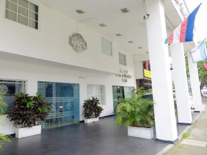 Un edificio con plantas en macetas en frente de él. en Hotel Santa Cecilia Cali, en Cali