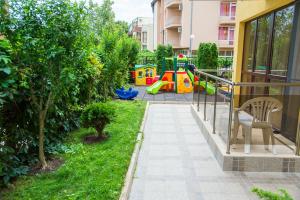 a garden with a playground in a building at Apart Lev in Ravda