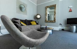 a living room with a couch and a mirror at Beachview in Eastbourne