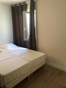 バニューにあるAppartement tout confort à 10 minutes de parisのベッドとカーテンのついた窓のある寝室