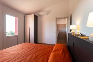 a bedroom with a bed and a desk and a window at Giardino sulla Maremma in Grosseto