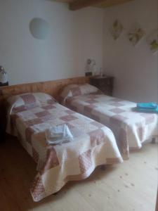 two beds sitting next to each other in a room at Il Càssero in Pomaretto