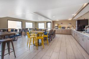 restaurację z żółtymi krzesłami i stołami oraz kawiarnię w obiekcie Days Inn Merced / Yosemite Area w mieście Merced