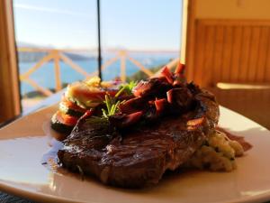 a plate of steak and potatoes on a table at Patagonia Acres Lodge in Mallin Grande