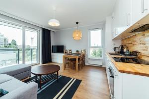 cocina y sala de estar con sofá y mesa en PoBookowane Stocznia Apartments Gdańsk en Gdansk