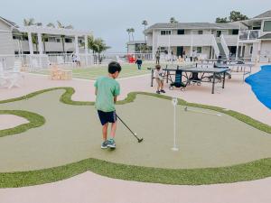 a young boy playing golf on a golf course at Pismo Lighthouse Suites in Pismo Beach
