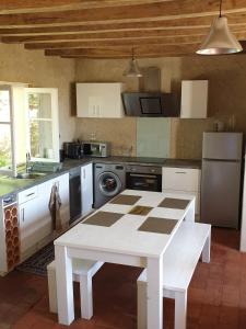 a kitchen with a white table and a white counter top at Bois logis in Bléré