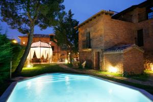 a swimming pool in front of a house at Hotel Boutique Real Casona De Las Amas in Azofra