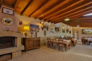a restaurant with a fireplace and tables and chairs at Al Lago Verde in Alia