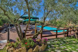 a pool with a fence and flowers in a yard at Al Lago Verde in Alia