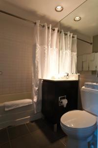 a bathroom with a toilet and a tub and a sink at Albion Hotel in Miami Beach