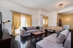 un soggiorno con due divani e un tavolo di Leone Luxury Villas a Kalamákion