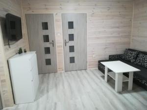 a living room with a couch and a table at Bajkowe Chatki in Rusinowo