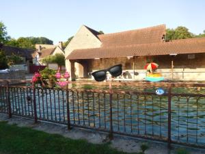 a pool of water with a house and a house with a swimming pool at Au 24 in Villiers-Louis