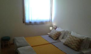 una camera da letto con letto, cuscini e finestra di apartamento a Porto