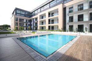 a swimming pool in front of a building at APARTMENTS GH - Accra - Cantonments - Embassy Gardens in Accra