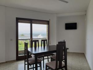 a dining room with a table and chairs and a window at Apartamentos O Cargadeiro Ribadeo in Ribadeo